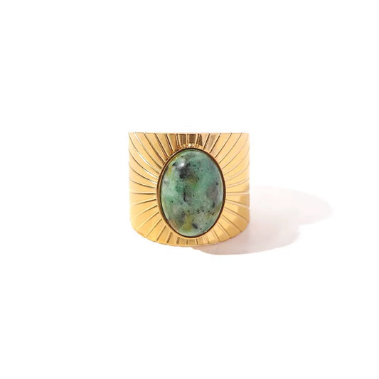 Bague Sandro LUNARA – chevalière large dorée motif solaire strié avec pierre turquoise naturelle cabochon, vue de face fond blanc