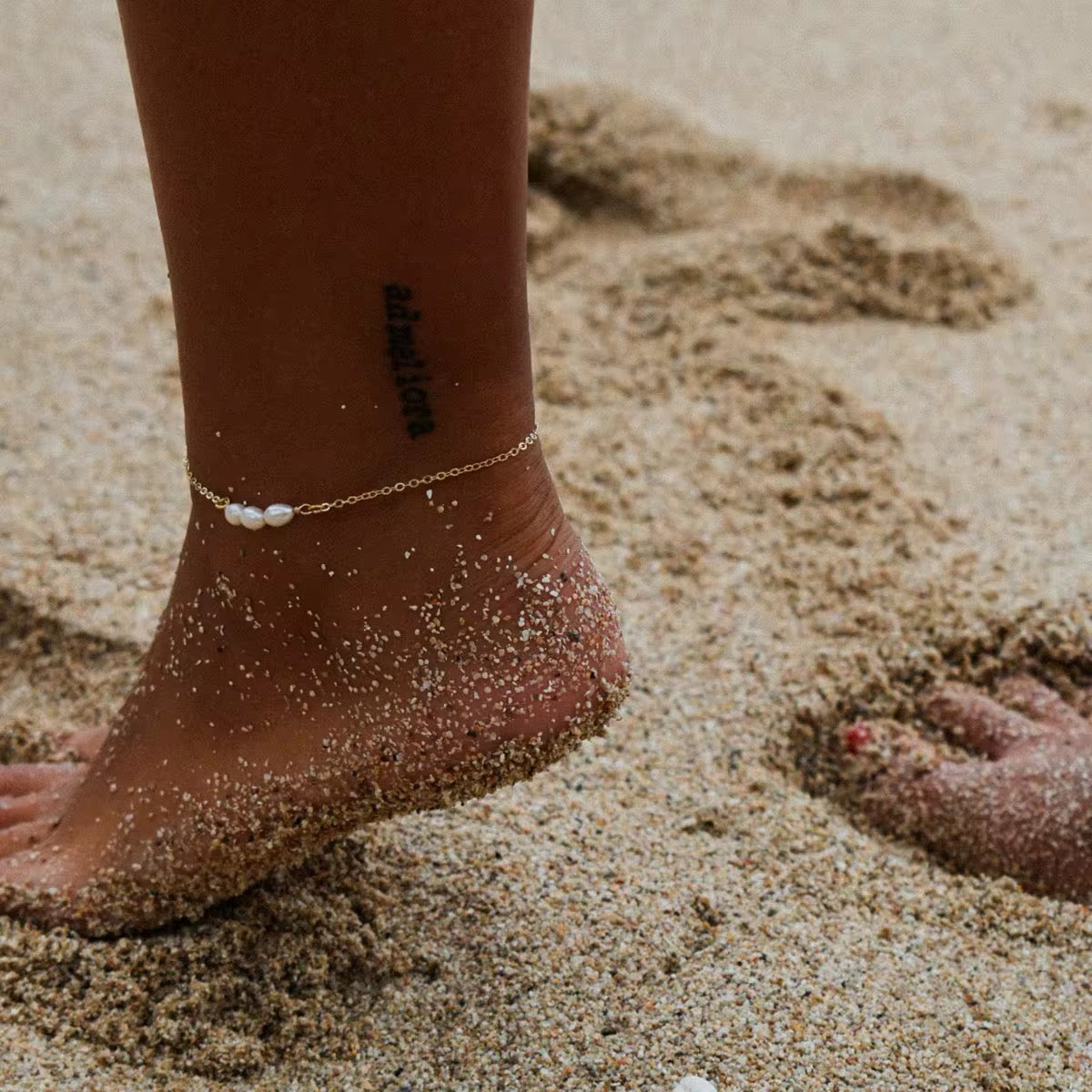 Bracelet de cheville Elma avec perles d'eau douce porté sur une cheville à la plage