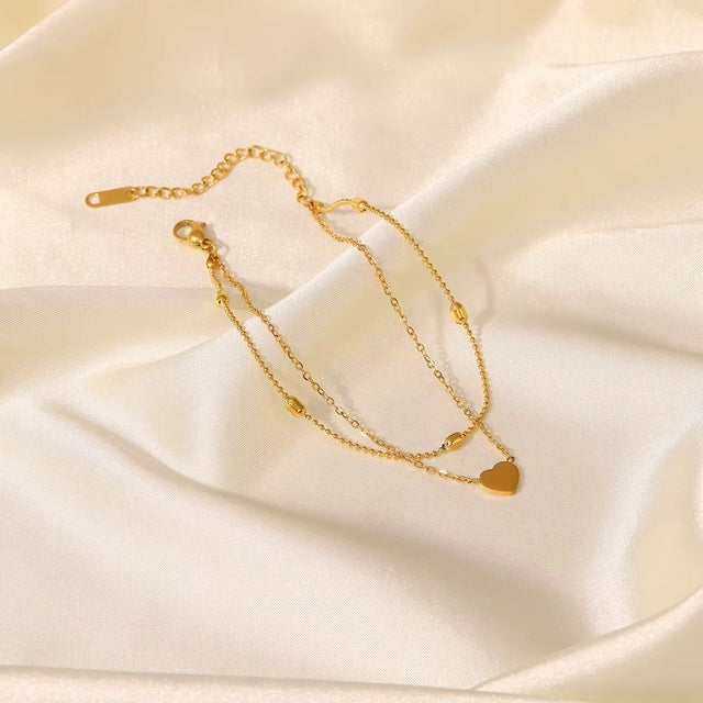 Bracelet de cheville Meryl doré double rang avec pendentif cœur sur tissu blanc