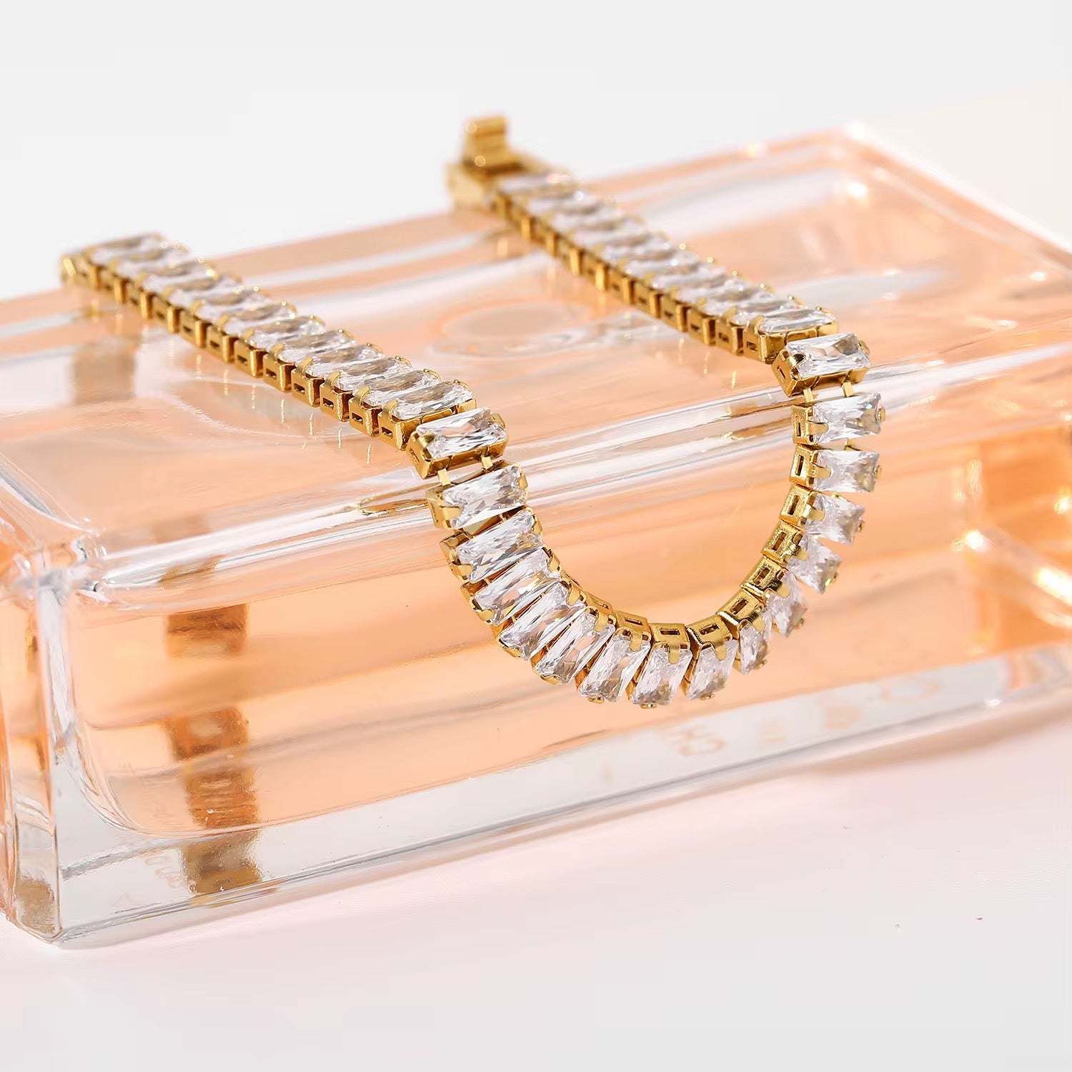 Bracelet Luna baguette zircon doré posé sur boîte transparente — vue lifestyle