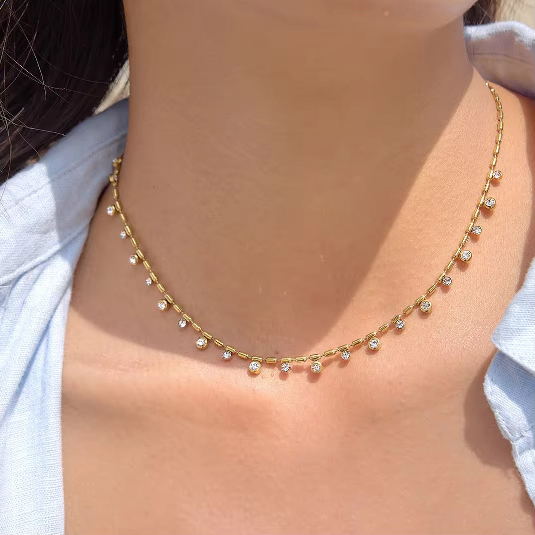 Collier Maya – flat lay sur coquillage blanc ambiance lumière dorée